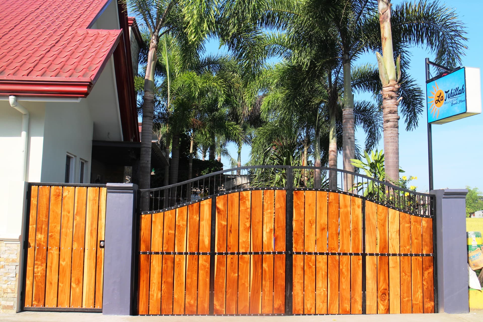 La Tehillah Private Resort entrance gate with wooden panels and palm trees