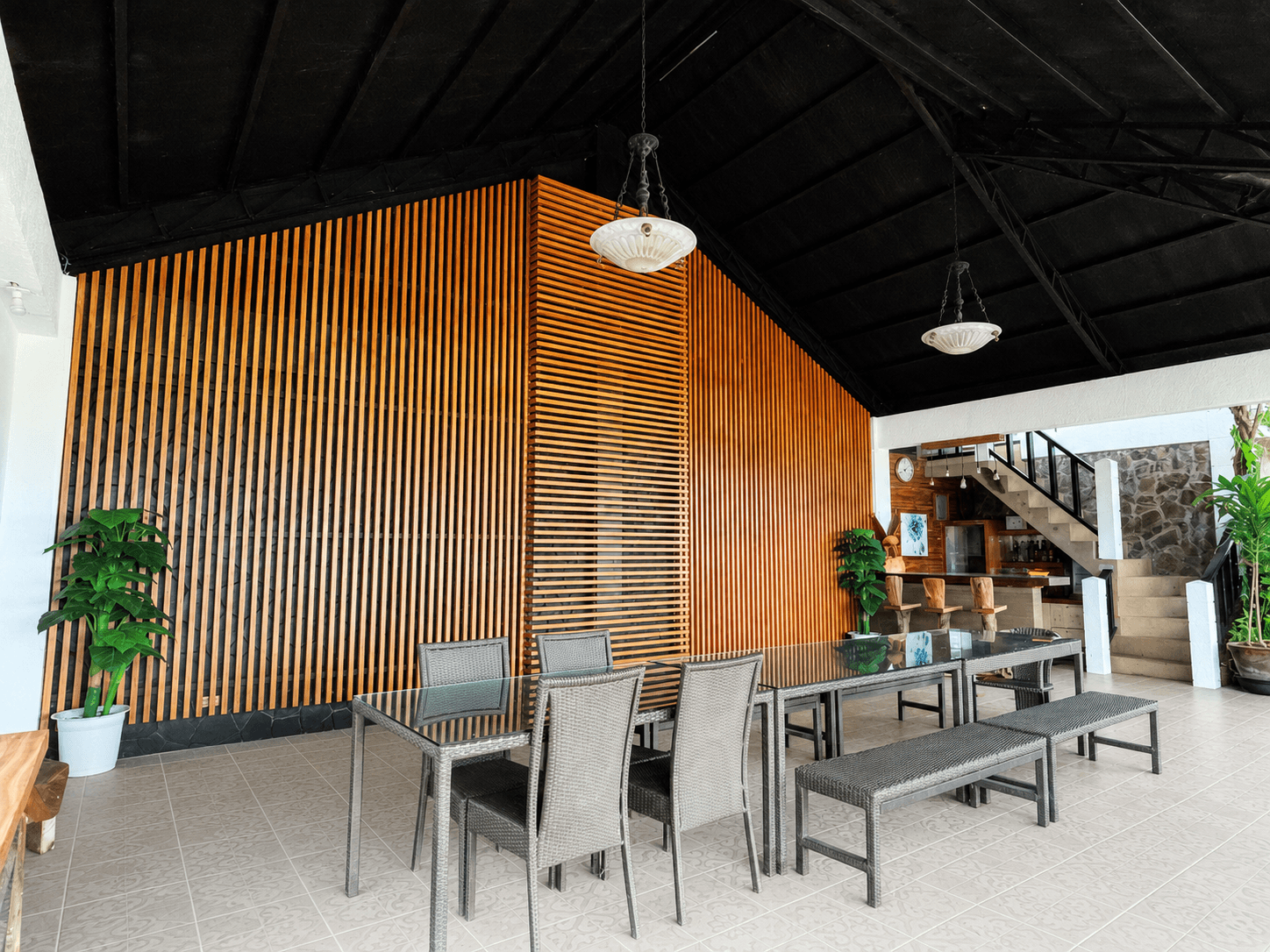Covered pavilion with wooden slatted walls and dining tables at La Tehillah