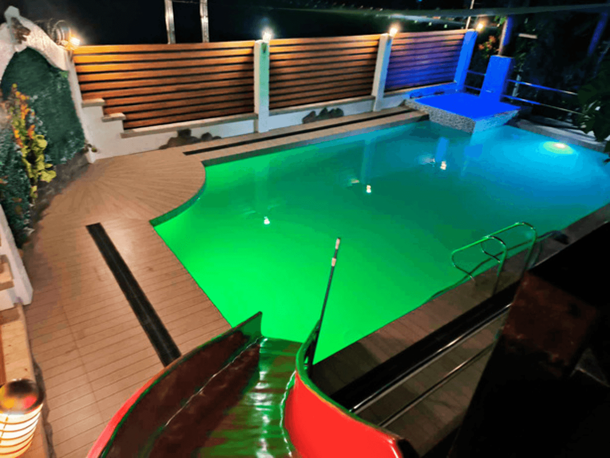La Tehillah swimming pool lit up at night with green and yellow LED lights
